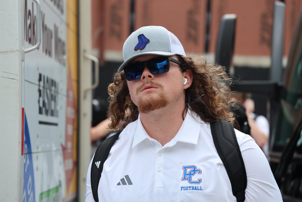 PC Football player wearing Garnet & Blue ball cap.